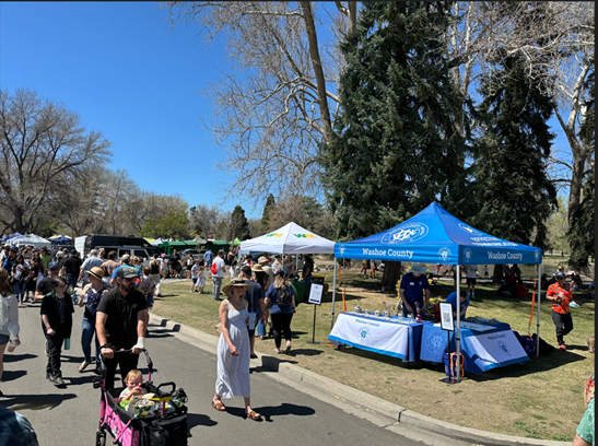 People walk alongside Washoe County's tent at Earth Day